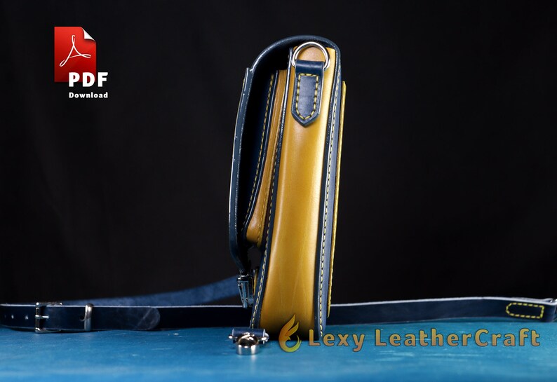 May include: A yellow leather crossbody bag with a blue leather trim and a silver metal buckle. The bag has a strap that is attached to the bag with a silver metal ring.