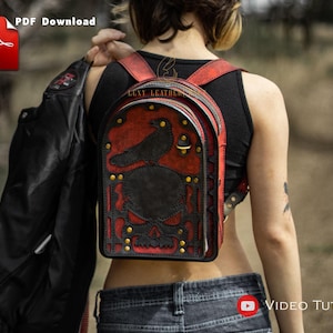 Può includere: Uno zaino in pelle rosso e nero con un design a forma di teschio e corvo. Lo zaino ha una fibbia in metallo e rivetti. Lo zaino è indossato da una persona.