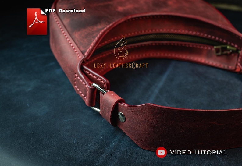 May include: A burgundy leather handbag with a curved design. The bag features a zipper closure and a strap with a silver-colored buckle. The text "PDF Download" and "Video Tutorial" are visible. The brand name "Lexy Leathercraft" is also visible.