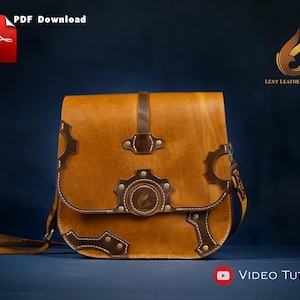 Puede incluir: Un bolso bandolera de cuero color marrón claro con detalles en marrón oscuro y adornos en forma de engranaje. El bolso tiene un cierre de solapa y una correa larga. Se ven las palabras "PDF Download" y "Video Tutorial".