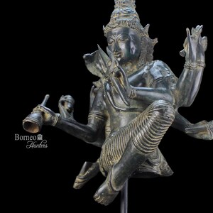 May include: A four-armed bronze statue of a deity, wearing a crown and featuring intricate details. The statue is holding a musical instrument in one hand and has a serene expression.