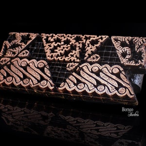 Op de afbeelding: Een set van vier houten drukblokken met ingewikkelde geometrische patronen die in het oppervlak zijn gegraveerd. De blokken zijn gemaakt van donker hout en hebben een roodbruine kleur. De patronen doen denken aan traditionele Indonesische batik-ontwerpen.