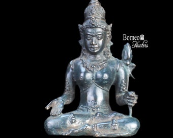 May include: A small, dark green bronze statue of a seated female figure with a crown and a lotus flower in her hand. The statue is on a black background.