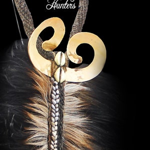 May include: A traditional tribal necklace with a bone pendant, fur trim, and a gold-colored metal design. The necklace is adorned with a decorative metal piece with a double-loop design. The text "Borneo Hunters" is visible on the necklace.