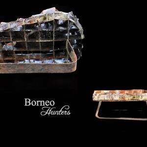 May include: Two rusty metal cages, one with a rectangular shape and the other with a round shape. The cages are made of metal bars and have a rustic appearance. The text "Borneo Hunters" is visible in the image.