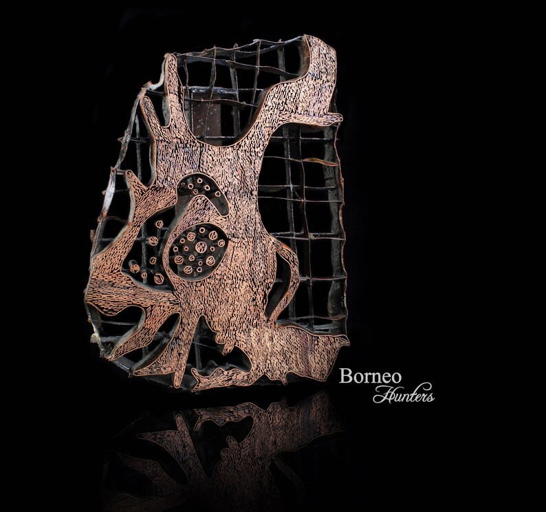 May include: A copper-colored batik stamp with a geometric design. The stamp is made of wood and has a grid pattern. The text "Borneo Hunters" is visible in the lower right corner of the image.