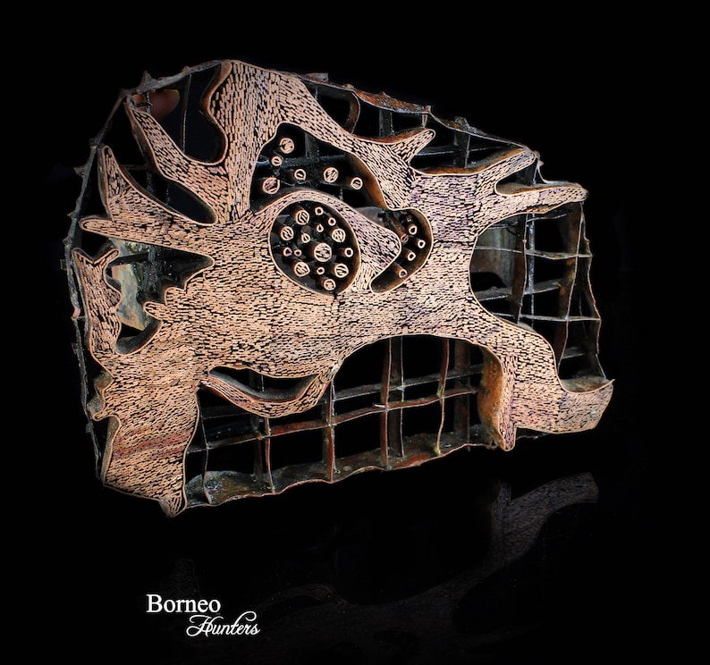 May include: A copper-colored batik stamp with a geometric design. The stamp is made of metal and has a raised design. The stamp is used to create patterns on fabric.
