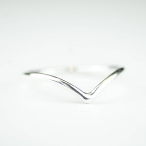 Può includere: Un anello d'argento semplice con un design a forma di V.