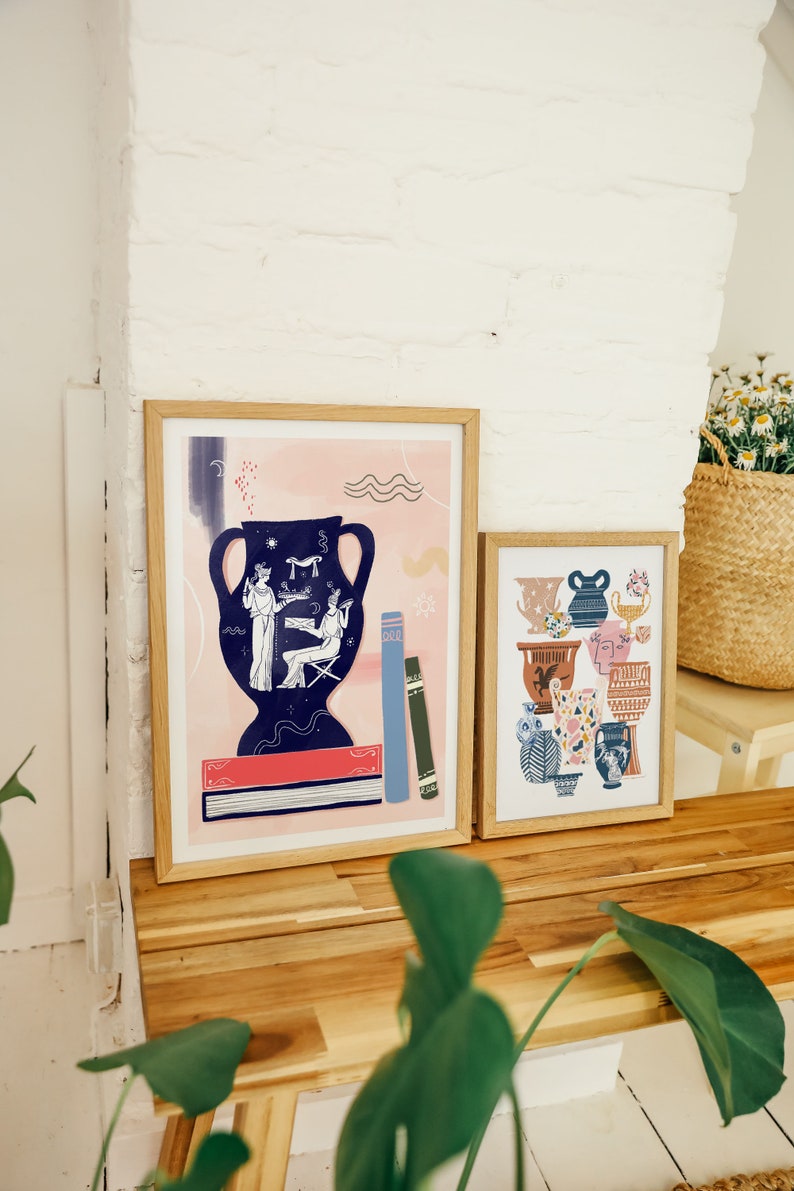 May include: Two framed prints with a pink and blue color scheme. The print on the left features a blue vase with a scene of two figures. The print on the right features a collection of colorful vases.