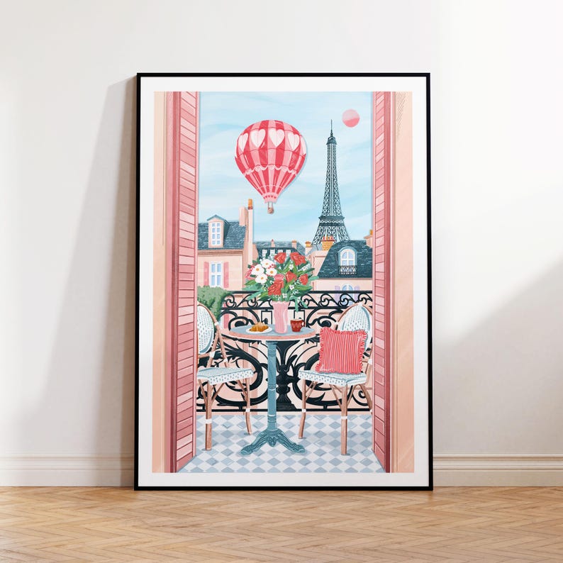 May include: A pink and white hot air balloon floats over a Parisian balcony scene with a view of the Eiffel Tower. Two chairs and a table with a cup of coffee and a pastry are set on the balcony. The balcony is decorated with pink flowers.