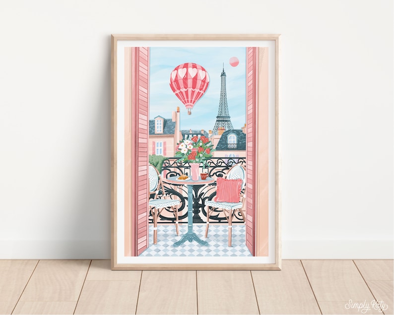 May include: A framed illustration of a Parisian balcony with a table and chairs, a hot air balloon in the shape of a heart, and the Eiffel Tower in the background.