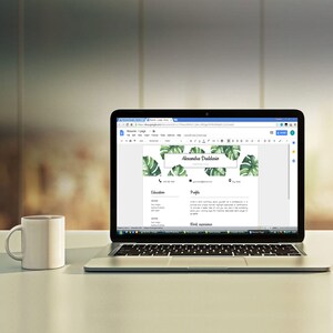May include: A laptop computer displaying a resume template with a tropical leaf design. The resume is for Alexandra Dudladio and includes contact information, education, profile, and work experience sections.