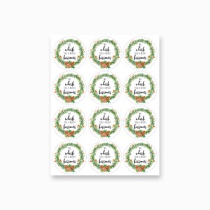 May include: Twelve round, white gift tags with a green wreath design and the text "We whisk you a merry kissmas".
