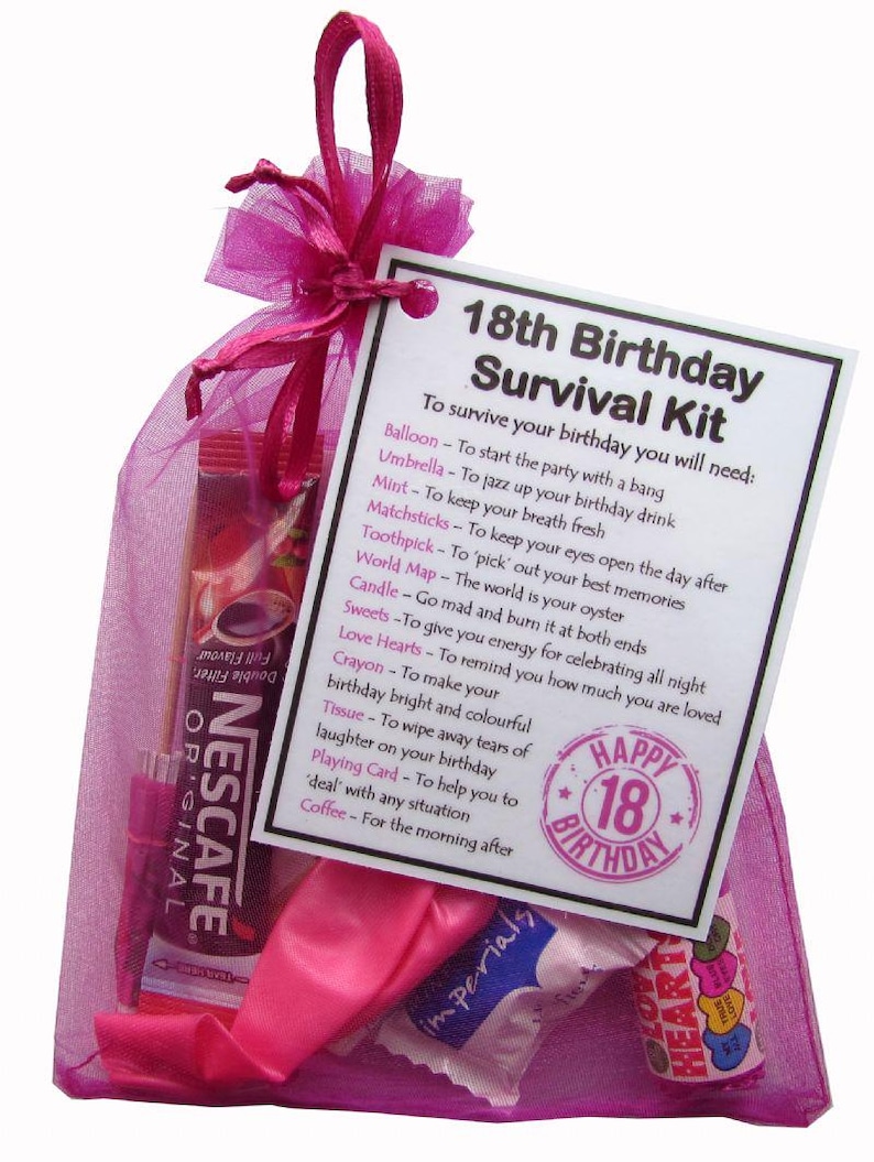 May include: A pink mesh gift bag containing an 18th Birthday Survival Kit. The kit includes a Nescafe coffee packet, sweets, a playing card, and a tag with a list of items. The tag reads "Happy 18th Birthday".
