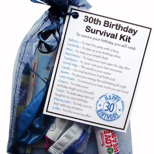 Puede incluir: Una bolsa de organza azul llena de un kit de supervivencia para un 30 cumplea&ntilde;os. El kit incluye un globo, un paraguas, menta, cerillas, un palillo de dientes, un mapa del mundo, una vela, dulces, corazones de amor, un cray&oacute;n, un pa&ntilde;uelo, una carta de juego y caf&eacute;. La bolsa tiene una etiqueta que dice "Kit de supervivencia para un 30 cumplea&ntilde;os" y enumera los art&iacute;culos incluidos en el kit.