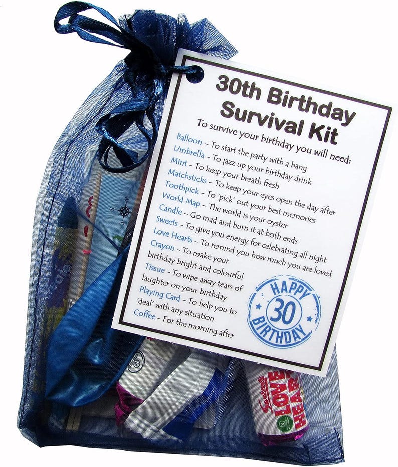 Puede incluir: Una bolsa de organza azul llena de un kit de supervivencia para un 30 cumplea&ntilde;os. El kit incluye un globo, un paraguas, menta, cerillas, un palillo de dientes, un mapa del mundo, una vela, dulces, corazones de amor, un cray&oacute;n, un pa&ntilde;uelo, una carta de juego y caf&eacute;. La bolsa tiene una etiqueta que dice "Kit de supervivencia para un 30 cumplea&ntilde;os" y enumera los art&iacute;culos incluidos en el kit.