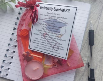 May include: A University Survival Kit in a red organza bag, containing a card with text, a candle, a balloon, a jigsaw piece, and other small items. A pen and notebook are in the background.