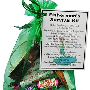 K&ouml;nnte beinhalten: Eine gr&uuml;ne Netz-Tasche gef&uuml;llt mit kleinen Geschenken und einer Karte mit der Aufschrift "Fisherman's Survival Kit" mit einer Liste von Gegenst&auml;nden und deren Verwendung. Die Gegenst&auml;nde umfassen ein Pflaster, Taschent&uuml;cher, S&uuml;&szlig;igkeiten, Zahnstocher, Liebesherzen, Regenschirm, Sicherheitsnadel, Puzzle-Teil, Schnur, Kaffee, Teebeutel, Gummiband und Konfetti.