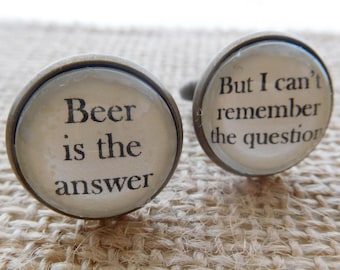 May include: A pair of cufflinks with a silver finish. One cufflink features the text "Beer is the answer" and the other cufflink features the text "But I can't remember the question".
