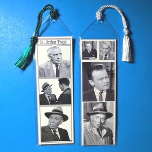 May include: Two vintage bookmarks featuring black and white images of a man in various poses. One bookmark has the text "Lt. Arthur Tragg". Each bookmark has a tassel at the top, one green and one white, attached by a clear plastic loop.