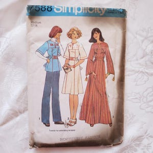 May include: Vintage Simplicity sewing pattern featuring three women's fashion designs. The pattern includes a blue top and pants, a white dress, and a long red dress. The pattern size is Medium 12-14. The text "Transfer for embroidery included" is visible.