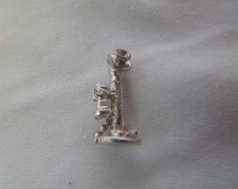 May include: Silver charm in the shape of a vintage rotary phone. The charm is detailed with a bell, dial, and handset.