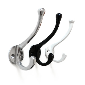 May include: Three metal hooks in silver, black, and white. The hooks are mounted on a wall and have a curved design.
