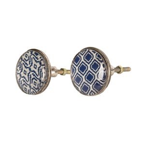 Könnte beinhalten: Zwei Schrankknöpfe mit silbernen Metallsockeln und Schrauben, verziert mit einem blauen und weißen Muster.