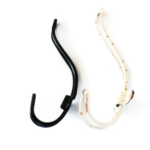 May include: Two metal hooks, one black and one white with rust spots. The hooks are curved and have a simple design.