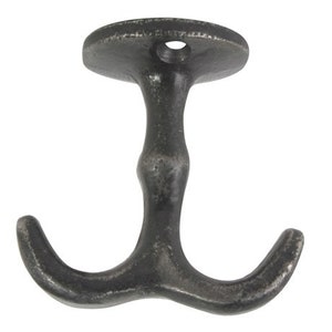 Op de afbeelding: Een zwarte metalen dubbele haak met een ronde basis. De haak is ontworpen om items aan een muur te hangen.