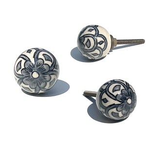 Peut inclure: Trois boutons de porte en céramique blanche avec un motif floral bleu. Les boutons ont une vis au dos pour les fixer à une porte de placard.