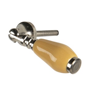 May include: A ceramic cabinet knob with a yellow glaze and a silver metal base. The knob is shaped like a teardrop and has a screw on the back.