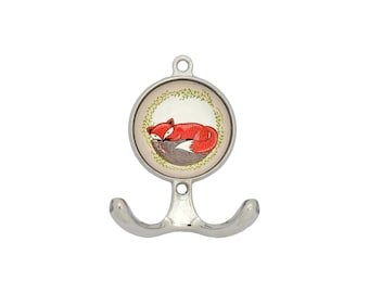 May include: A silver double hook with a round, white and green ceramic knob featuring a red fox illustration.