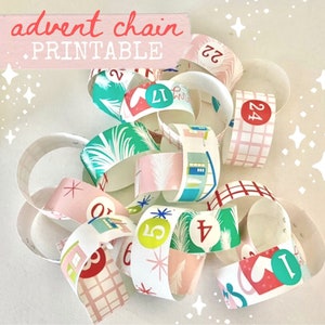 May include: A printable advent chain with pink, green, and white paper rings. Each ring has a number from 1 to 24 printed on it. The text "advent chain - printable" is printed on a pink banner.