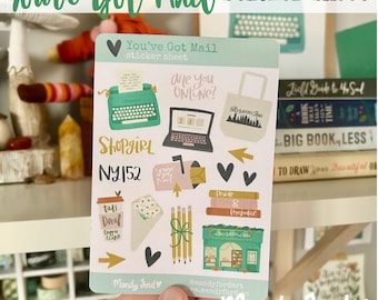 May include: A sticker sheet with a light blue background featuring illustrations of a typewriter, a laptop, a coffee cup, a mailbox, a book, a shop, and a heart. The text "You've Got Mail" is printed in black at the top of the sheet. The text "Shopgirl NY152" is printed in black at the bottom of the sheet.