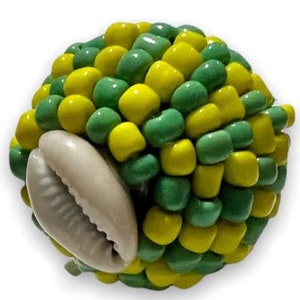 May include: A green and yellow beaded sphere with a white cowrie shell attached. The beads are arranged in a pattern.