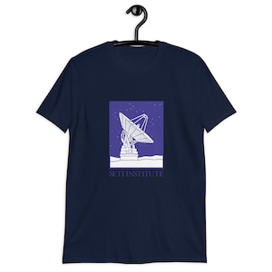 May include: Navy blue t-shirt with a white illustration of a radio telescope against a purple starry sky. The text "SETI INSTITUTE" is printed below the illustration.