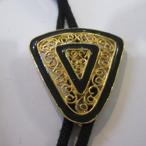Designs Bolo Tie, Costume Handcrafted  Ornate Gold Tone Filigree Designs Black Background Bolo Tie IC Lot 38