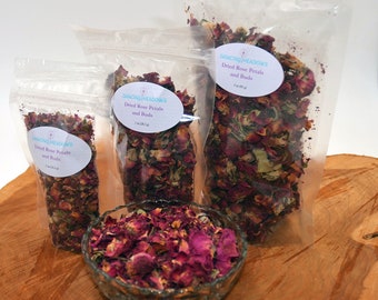 May include: Three clear plastic bags filled with dried rose petals and buds. The bags are labeled "Dancing Meadows Dried Rose Petals and Buds" with the size of the bag in ounces. A small glass bowl filled with dried rose petals and buds is in the foreground.