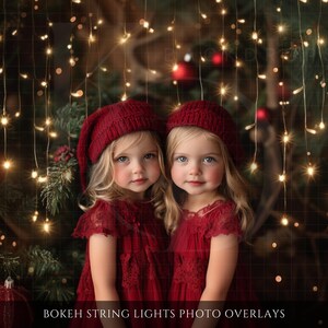 May include: Two young girls wearing matching red dresses and knit hats, posing in front of a Christmas tree with string lights. The image has a soft focus and a warm, festive feel. Text at the bottom reads "Bokeh String Lights Photo Overlays."