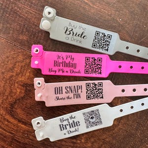 May include: Four colorful event wristbands with text and QR codes. The wristbands are pink, light pink, and silver. The text on the wristbands includes "Buy the Bride a Drink," "It's My Birthday Buy Me a Drink," and "OH SNAP! Share the FUN."