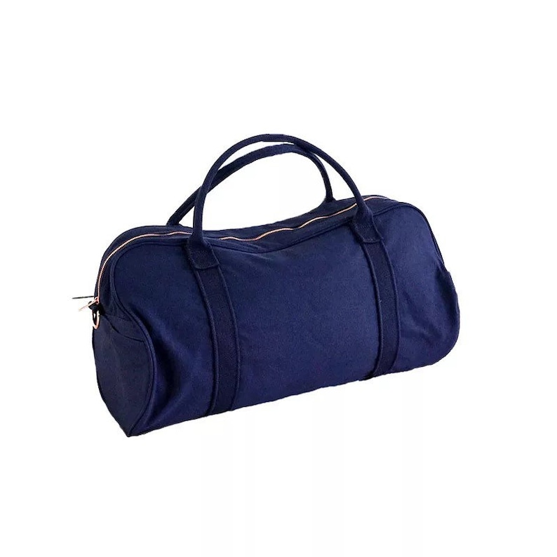 May include: A navy blue canvas duffel bag with rose gold accents and a zip closure.