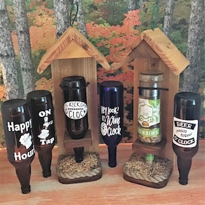 May include: Four wooden bird feeders with glass bottles attached. The bottles have various designs and sayings, including "Happy Hour", "On Tap", "It's Kickoff O'Clock", "Hey Look! It's Wine O'Clock", and "Beer O'Clock".