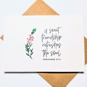 May include: A white greeting card with the text "a sweet friendship refreshes the soul" and "PROVERBS 27:9". The card features a floral design with green leaves and pink berries. The card is inside a brown envelope.