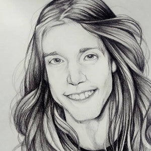 May include: A black and white pencil drawing of a person with long hair smiling. The person is wearing a dark shirt.