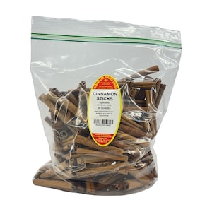 May include: A clear plastic resealable bag filled with brown cinnamon sticks. A yellow oval label on the front reads Marshalls Creek Spices, Cinnamon Sticks, 20 ounces, ingredients cinnamon sticks, and includes a barcode and contact information.