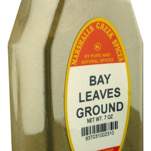 May include: A glass jar of ground bay leaves, labeled "Marshalls Creek Spices" with a red and yellow label. The label reads "Bay Leaves Ground" and "Net Wt. 7 oz".