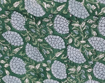 Può includere: Un tessuto verde con un motivo ripetitivo di fiori blu e foglie verdi.
