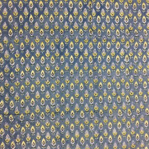 May include: A blue fabric with a repeating pattern of small yellow and white flowers.