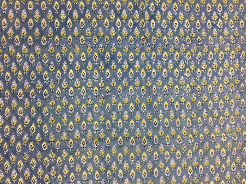 May include: A blue fabric with a repeating pattern of small yellow and white flowers.